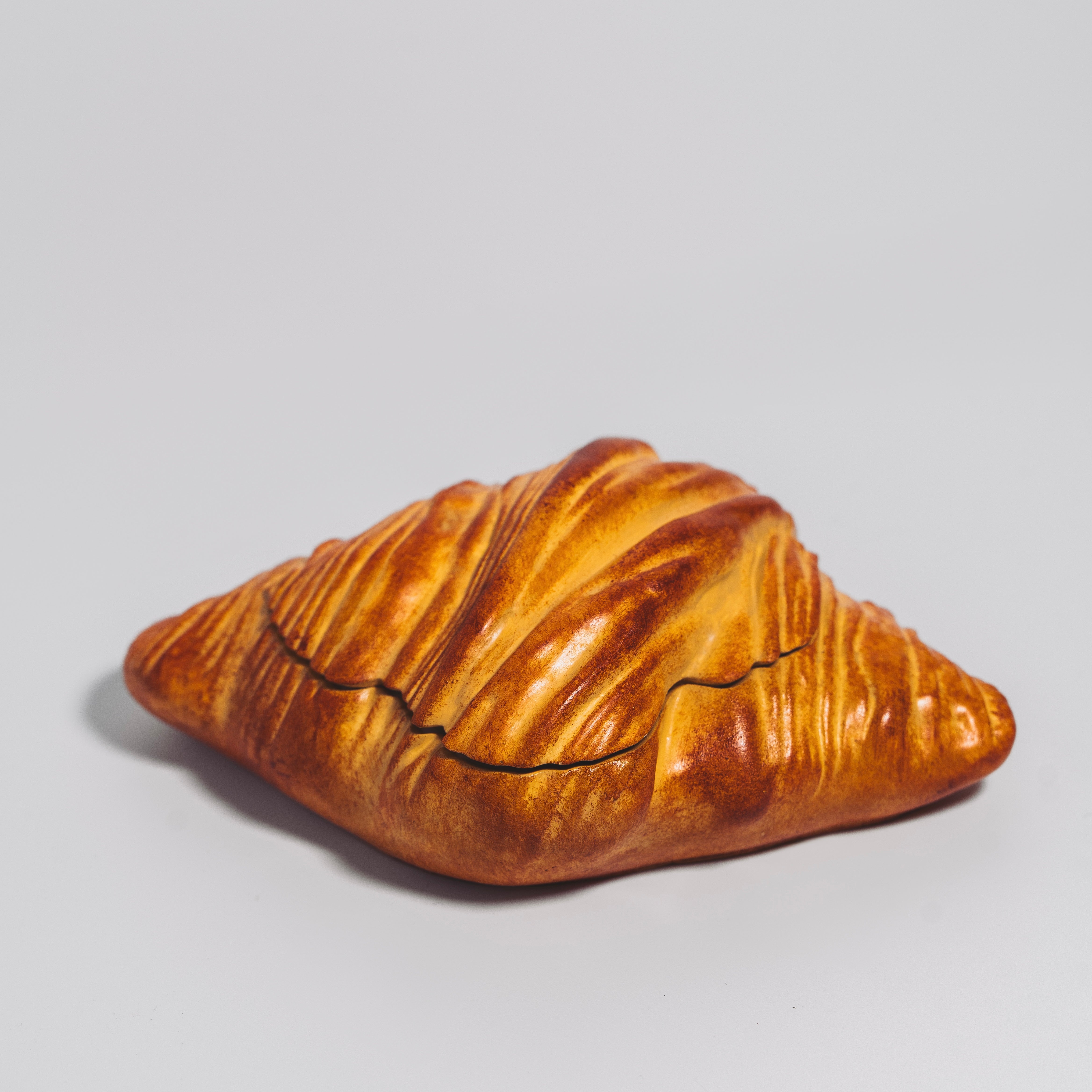 Sculptural croissant candle handmade and hand-painted in Los Angeles